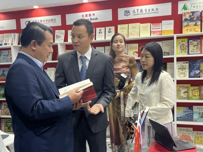 泰國書(shū)商和出版商協(xié)會(huì )主席蘇維奇（左一）在翻閱《近鏡頭：溫暖的瞬間》。（盧雯 攝）jpg_副本.jpg