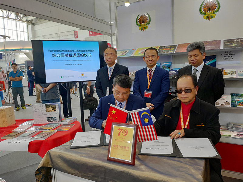 廣西師范大學(xué)出版社集團黨委書(shū)記、董事長(cháng)張藝兵（左前一）與馬來(lái)西亞國家語(yǔ)文出版局理事長(cháng)Datuk Abang Sallehuddin Abang Shokeran簽訂合約（陳子鋒攝）.jpg