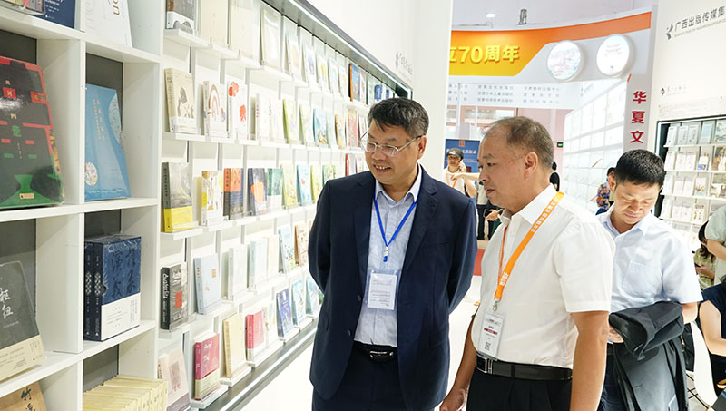 集團公司黨委書(shū)記、董事長(cháng)張藝兵向校黨委副書(shū)記趙鐵詳細介紹出版社圖書(shū)（陳子鋒攝）.JPG